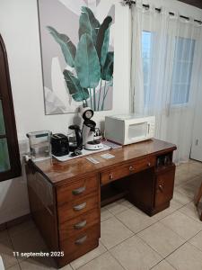 a microwave sitting on top of a wooden desk at Porte de Mafate - Grand Ilet in Salazie +42 photos