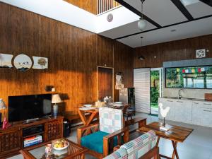 a living room with wood paneling and a television at Villa Kaavan in Rāmgarh
