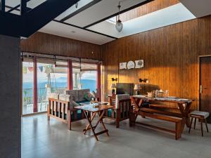a living room with wooden walls and a table and chairs at Villa Kaavan in Rāmgarh