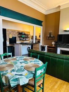 a dining room with a table and a couch at Le Marmont 3 bedrooms center private parking in Saint-Étienne