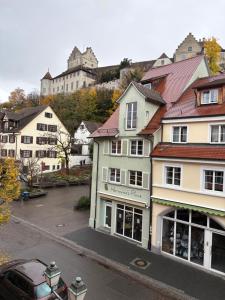 a building with a car parked in a parking lot at Hotel Iris- Pizzeria Ristorante La Taverna in Meersburg