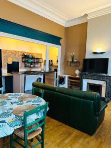 a living room with a green couch and a table at Le Marmont 3 bedrooms center private parking in Saint-Étienne +16 photos