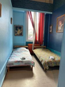two beds in a blue room with a window at Le Marmont 3 bedrooms center private parking in Saint-Étienne