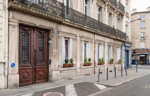 a building with doors and potted plants on a street at Le Marmont 3 bedrooms center private parking in Saint-Étienne