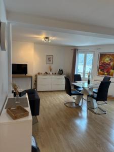 Una gran sala de estar con mesa y sillas. en Le Cocon Chalonnais, en Châlons-en-Champagne 2 fotos más