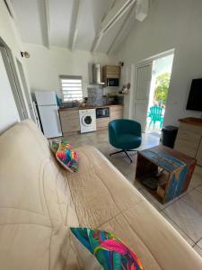 a living room with a couch and a table at Coco-orchidées Le Domaine Mannou in Sainte-Rose