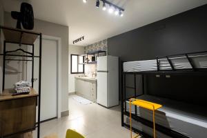 a room with two bunk beds and a yellow chair at 108-Studio funcional com treliche prox UEL in Londrina