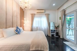 una camera da letto con un grande letto bianco con una finestra di Platinum Villa Rawai 76 a Rawai Beach Altre 74 foto
