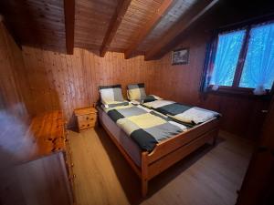 a bedroom with a bed in a wooden room at Gemütliches Chalet mit Kamin&Seeblick in Oberterzen Flumserberg in Oberterzen