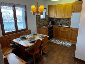 a kitchen with a wooden table with bowls on it at Gemütliches Chalet mit Kamin&Seeblick in Oberterzen Flumserberg in Oberterzen