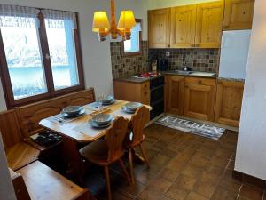 a kitchen with a wooden table with bowls on it at Gemütliches Chalet mit Kamin&Seeblick in Oberterzen Flumserberg in Oberterzen +15 photos