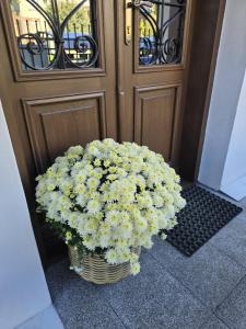 een mand met bloemen voor een deur bij Apartamenty CAPPUCCINO in Przemyśl