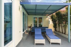 un patio con sedie imbottite blu e un baldacchino blu di Platinum Villa Rawai 76 a Rawai Beach