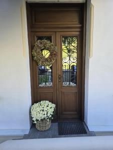 een houten deur met twee kransen en een mand met bloemen bij Apartamenty CAPPUCCINO in Przemyśl