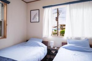 鎌倉市にあるKamakura Hase Houseの窓のある部屋にベッドが2つある