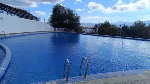 a large blue swimming pool with two metal handles at Cabo Dream 51 in Cabo Negro