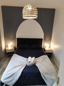 a bedroom with a bed with two white towels on it at Appartement Cosy in Louhans +1 photo