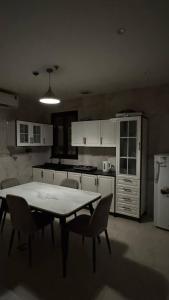 a kitchen with a table and chairs in it at نسمة الخبر سويت in Dammam