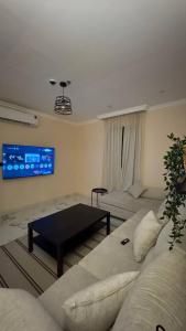 a living room with a couch and a table at نسمة الخبر سويت in Dammam