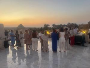 a group of people standing around looking at the sunset at Sun Temple Palace in Cairo