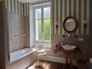 een badkamer met een bad, een wastafel en een spiegel bij Villa Champallement in Champallement +25 foto's