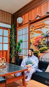 Eine Frau auf einer Bank in einem Zimmer in der Unterkunft Hanki Guest House syariah in Gadok 1