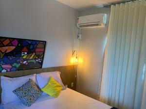 a bedroom with a bed with pillows and a fan at Apê 301 a 2,8 km da UFV in Viçosa