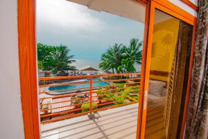 a room with a balcony with a view of the ocean at Résidence Hôtelière TAZ in Kribi +19 photos