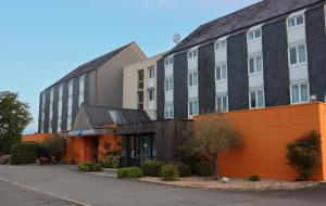a large building with an orange and black at ibis budget Lorient Hennebont in Hennebont