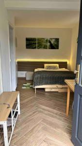 a bedroom with a bed and a wooden floor at Studio Ohlendorf 3 Min zur A7 in Seevetal
