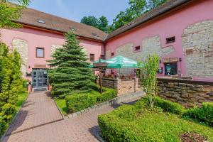 a pink building with a tree in front of it at Hotel STARÝ PIVOVAR in Prague