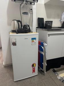 a white refrigerator with a blender on top of it at Flats Sol e Brisa in Marechal Deodoro