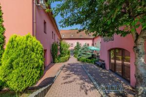 a walkway in front of a pink building at Hotel STARÝ PIVOVAR in Prague