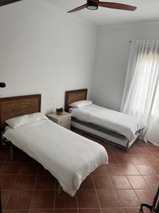 ein Schlafzimmer mit zwei Betten und einem Deckenventilator in der Unterkunft Casa Indalo in La Puebla de los Infantes