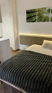 a bedroom with a large black blanket on a bed at Studio Ohlendorf 3 Min zur A7 in Seevetal