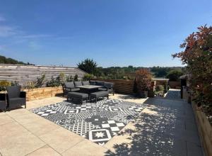 Un patio con una mesa y sillas en un patio. en The Bungalow by The Garden Spa Stays, 4 bed, Sauna - Hot Tub - Ice Bath, en Radstock