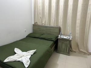 阿布扎比Unique Boutique - MBZ的一间卧室,里面有一张绿色的床,床上系着一个白色蝴蝶结。