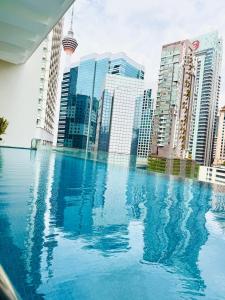 a swimming pool in a city with tall buildings at Crystal Suites at Ramad KLCC in Kuala Lumpur