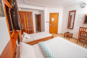 a small bedroom with two beds and a chair at Résidence Hôtelière TAZ in Kribi