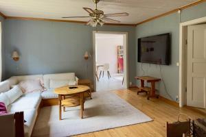 Una sala de estar con un sofá blanco y una mesa. en Idyllic Lake House in Sweden, en Klässbol