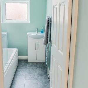 een badkamer met een bad, een wastafel en een toilet bij Pitchside House - sleeps 4 in Liverpool