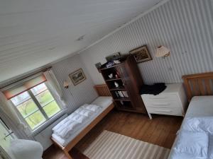 Un dormitorio pequeño con una cama y una ventana. en Idyllic Lake House in Sweden, en Klässbol