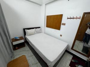Un dormitorio pequeño con una cama y un espejo. en Hotel Tayef Dhanmondi, en Dhaka