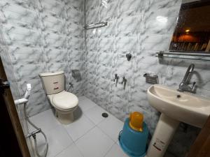 Un baño blanco con inodoro y lavabo. en Hotel Tayef Dhanmondi, en Dhaka