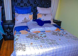 a bed with a blue comforter and pillows at E Point guest house in Johannesburg