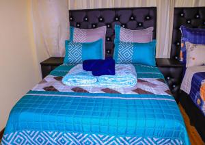 a bed with a blue comforter and pillows on it at E Point guest house in Johannesburg