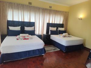 two beds in a hotel room with two at E Point guest house in Johannesburg