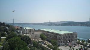 a large building next to the water with a bridge at Çırağan Hotel Bosphorus in Istanbul