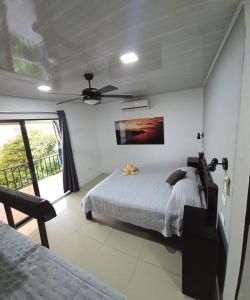 una camera da letto con un letto e un ventilatore a soffitto di Cabinas Nasua Drake a Bahía Drake Altre 23 foto