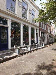 two chairs sitting outside of a building on a street at Het Zwanenest in Harlingen